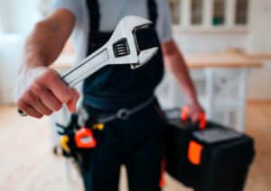 Handyman Holding a Monkey Wrench and Tool Box